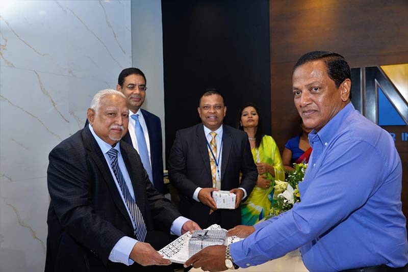 Chief Guest Harry Jayawardena accepting a deposit from Preethiraj De Silva at the opening ceremony as HNB Chairman Dinesh Weerakkody and HNB CEO/MD Jonathan Alles look on.
