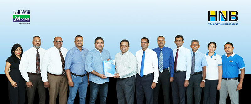 Nalin Perera, CEO of Mobitel exchanging the MoU with Jonathan Alles, Managing Director/CEO of HNB, flanked by HNB officials (right) and Mobitel officials (left)