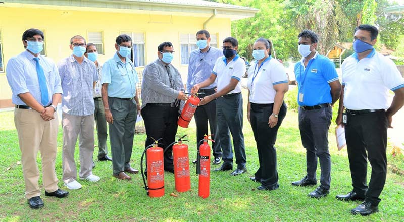 HNB Chairman Dinesh Weerakkody and Chief Operating Officer Dilshan Rodrigo present IDH Director Dr. Hasitha Attanayake (center) the fire extinguishers as Health Ministry official Dr. Hasitha Tissera, IDH Medical Officer Planning Dr. Azad Samad, Epidemiology/IDH Consultant Physician Dr. Ananda Wijewickrama, HNB Chief Transformation Officer Chiranthi Cooray, Senior Manager- Engineering Roshan Fernando and Officer in Charge of Sustainability Shanel Perera (left to right) look on.