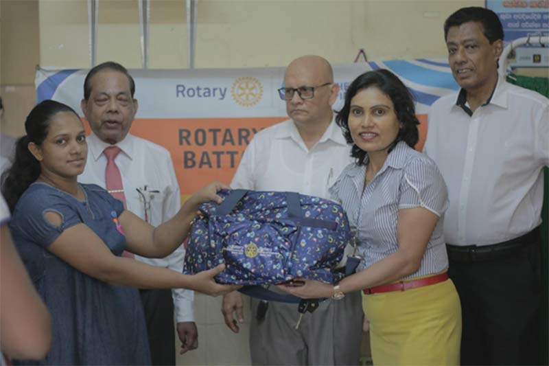 Rotarian Kumudu handing over a maternity Bag to a mother at the Talangama Base Hospital, in the presence of President Nelu Fernando (second from left) and Past Presidents Warren Solomonsz (center) and Ranjan Alles (right).
