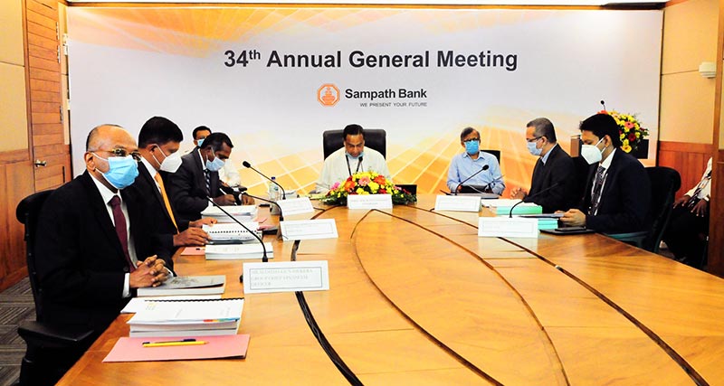Professor Malik Ranasinghe, Chairman, Sampath Bank PLC (centre) conducting the AGM. Also in the picture are Nanda Fernando, Managing Director, Sampath Bank PLC (third from left); Ranil Pathirana and Rushanka Silva, Non-Executive Directors (second from left and extreme right); Lasantha Senaratne, Company Secretary (second from right); Ajantha Gunasekara, Group Chief Finance Officer (extreme left) seated at the head table and Dr. Arittha Wikramanayake, Precedent Partner, Nithya Partners (third from right) and Sanath Fernando, Partner, Ernst & Young (fourth from left).