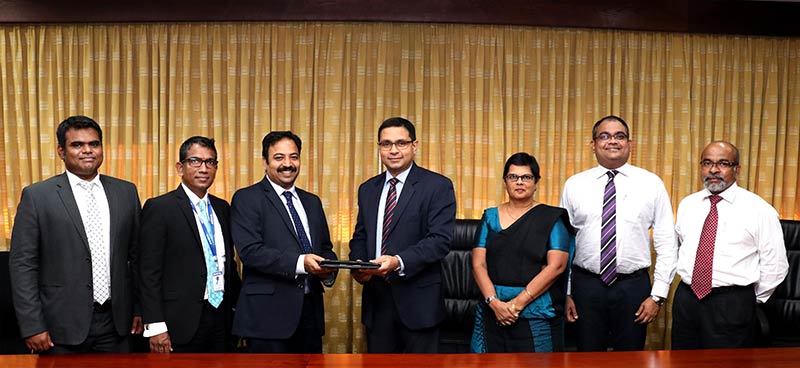Commercial Bank’s Chief Operating Officer Mr Sanath Manatunge (centre) and HCL Technologies Lanka (Pvt) Ltd. Resident Director Mr Thothathri Vaikuntam exchange the agreement in the presence of (from left) HCL Technologies Lanka (Pvt) Ltd. Manager – Corporate Mr Muthu Shankar Sivasubbu and General Manager – Operations Mr Dilan S Perera; Commercial Bank’s Deputy General Manager – Personal Banking Ms Sandra Walgama, Deputy General Manager – Marketing Mr Hasrath Munasinghe and Senior Manager – Retail Products Department Mr Dushmantha Jayasuriya.