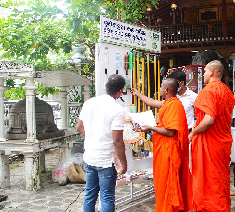 Lalithra Wickramasinghe, Executive, Coca-Cola Beverages Sri Lanka Ltd. demonstrates to priests at the Gangaramaya Temple how PET bottles are recycled by Eco Spindles Pvt. Ltd. and converted to value added products such as brooms, brushes and garments.