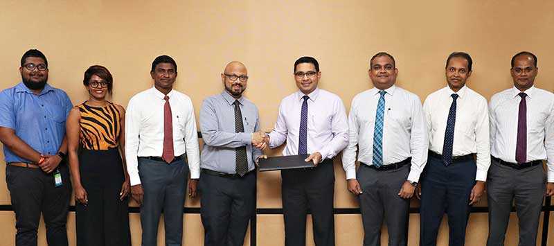 Commercial Bank’s Chief Operating Officer Mr Sanath Manatunge (4th from right) and Mobitel Chief Marketing Officer Mr Shashika Senarath exchange the agreement in the presence of (from left) from the Mobitel team,  Assistant Manager – Mobile Financial Services  Mr Gayan Kalugamage,  Manager – Mobile Financial Services Ms  Rishani Gunaratne and Senior General Manager – Marketing Mr Isuru Dissanayaka; Commercial Bank’s Deputy General Manager – Marketing Mr Hasrath Munasinghe, Head of Card Centre Mr Thusitha Suraweera and Senior Manager –  Card Centre Mr Seevali Wickramasinghe