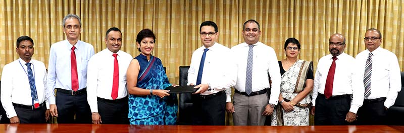 Commercial Bank’s Chief Operating Officer Mr Sanath Manatunge (centre) and Hayleys Agriculture Holdings Ltd. Managing Director Ms Jayanthi Dharmasena exchange the agreement in the presence of (from left) Hayleys Agriculture Holdings Ltd. Deputy General Manager Mr Sumith K Herath, Director Mr M A Rajap and Director Mr Lushan Abesekara; Commercial Bank’s Deputy General Manager – Marketing Mr Hasrath Munasinghe, Deputy General Manager – Personal Banking Ms Sandra Walgama, Senior Manager – Retail Products Department Mr Dushmantha Jayasuriya and Manager – Retail Products Department Mr Chandana Abeysundara.