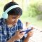 Indian Cute boy listening to music and using mobile phone